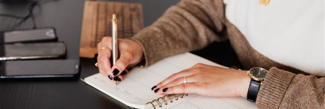 Photograph of someone writing a message in a notebook